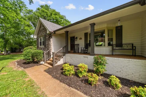 a front view of a house with a yard and outdoor seating