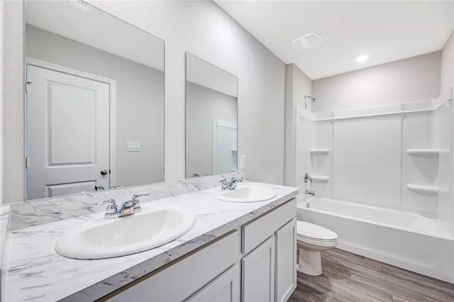 a bathroom with a sink double vanity granite toilet tub and shower