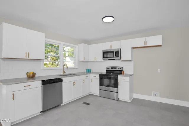 a kitchen with white cabinets and appliances