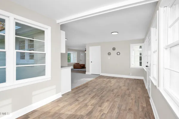 a view of a big room with wooden floor and windows