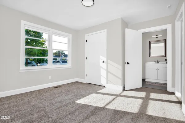 a view of an empty room with window and a livingroom
