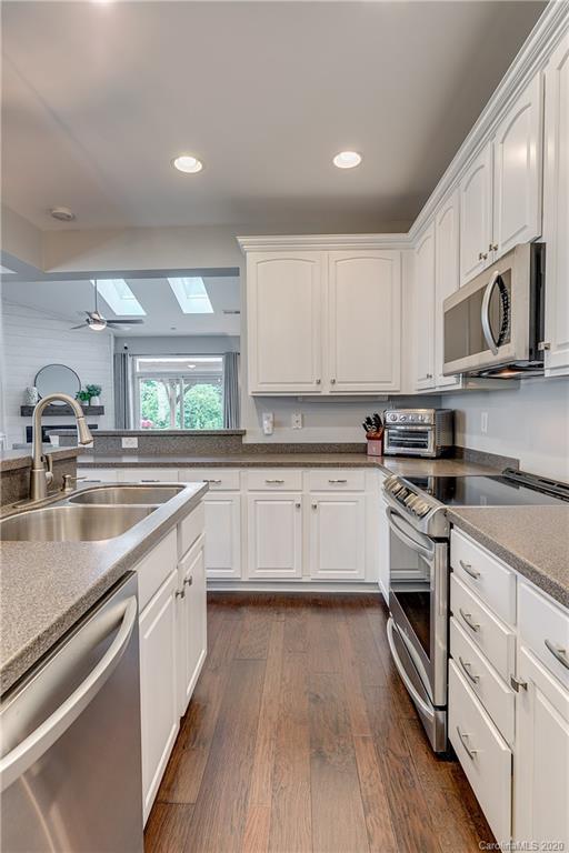 6743 Dusty Saddle Road Charlotte, NC 28277 - Photo 11 of 47 a kitchen with stainless steel appliances granite countertop a sink and stove top oven