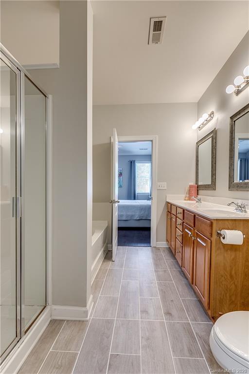 6743 Dusty Saddle Road Charlotte, NC 28277 - Photo 24 of 47 a bathroom with a double vanity sink a mirror and a bathtub