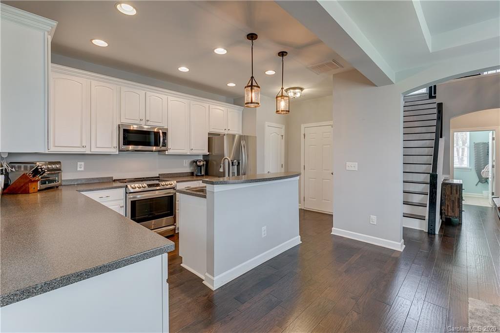 6743 Dusty Saddle Road Charlotte, NC 28277 - Photo 8 of 47 a kitchen with stove cabinets and wooden floor