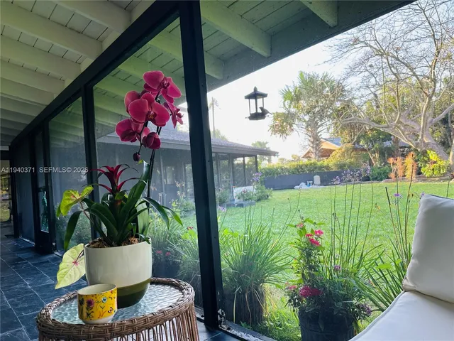 a vase of flowers sitting on a table with a potted plant