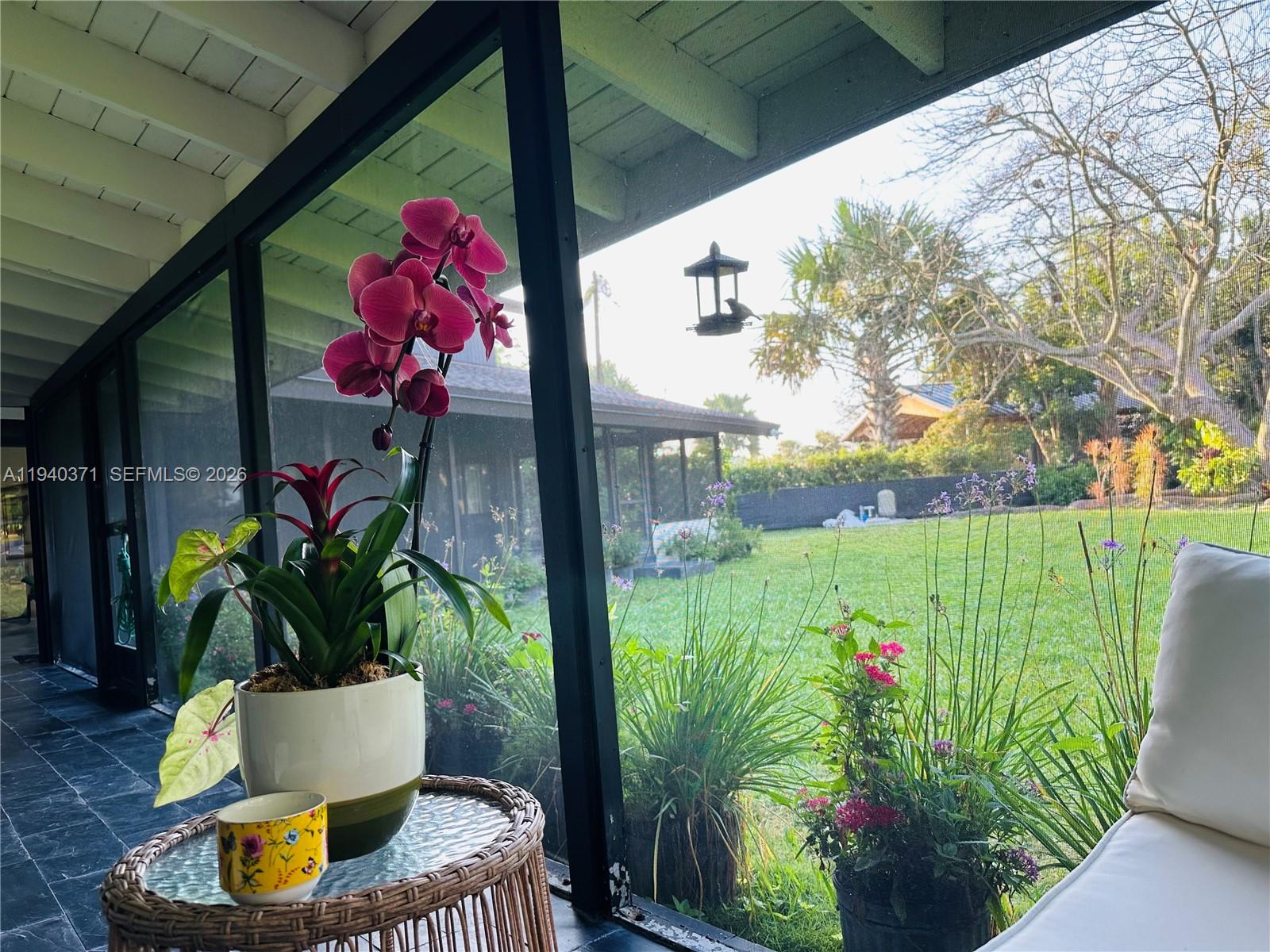 16470 Southwest 234th Street Homestead, FL 33031 - Photo 20 of 21 a vase of flowers sitting on a table with a potted plant