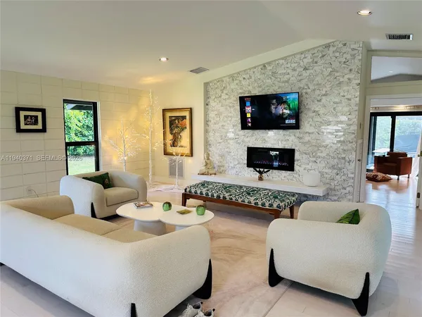 a living room with furniture a flat screen tv and a fireplace