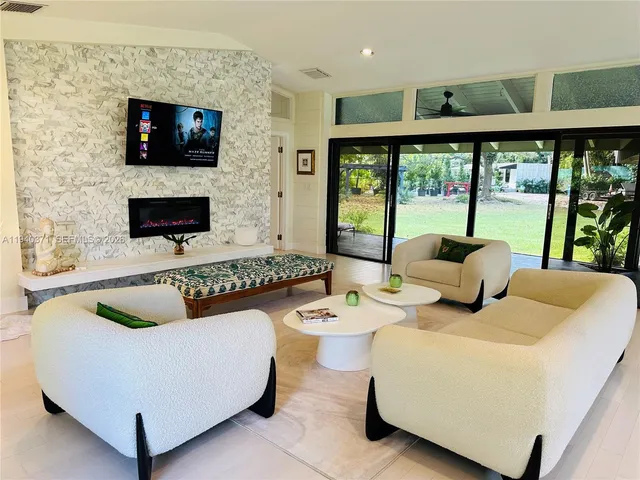 a living room with furniture a flat screen tv and a fireplace