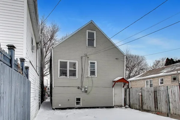 a view of a house with a wooden fence