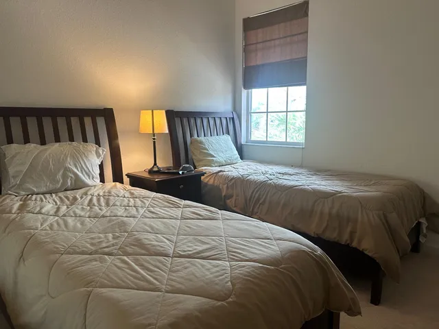 a bedroom with two beds and a window