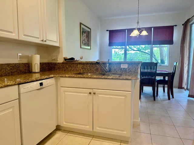 a kitchen with stainless steel appliances granite countertop white cabinets and a granite counter tops