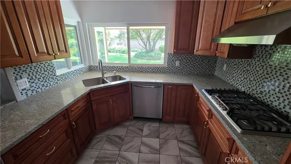 a kitchen with a sink a stove top oven a washer dryer and a window