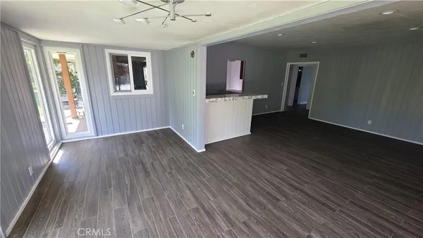 a view of a livingroom with wooden floor and a flat screen tv