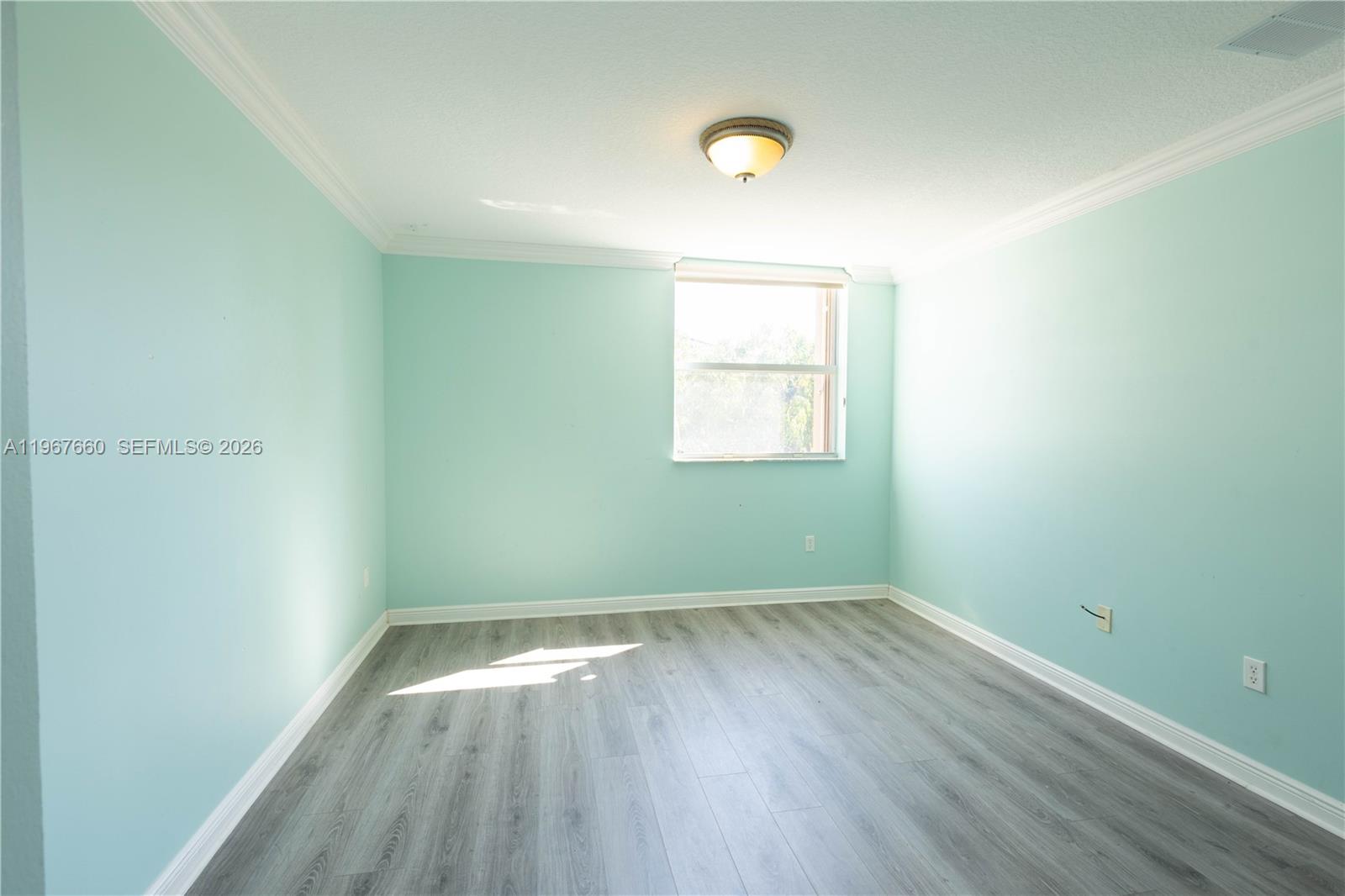 5331 Southwest 159th Avenue, Unit 5331 Miramar, FL 33027 - Photo 22 of 41 an empty room with wooden floor and windows