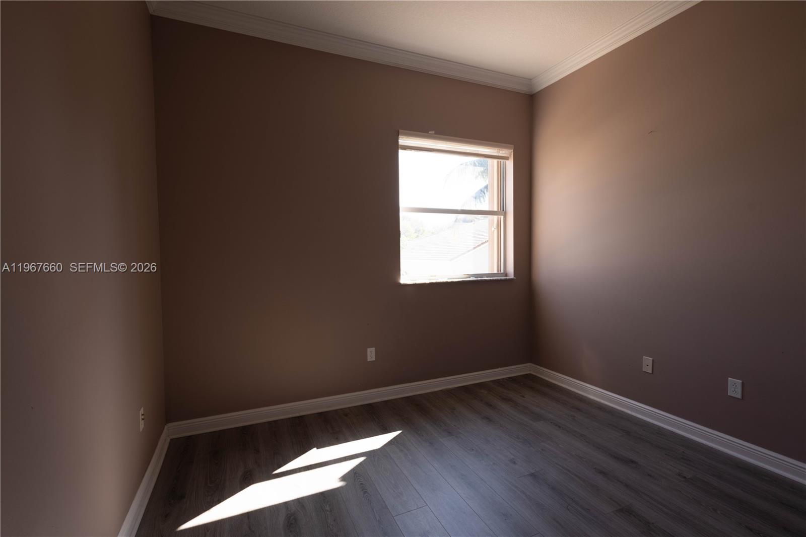 5331 Southwest 159th Avenue, Unit 5331 Miramar, FL 33027 - Photo 23 of 41 an empty room with wooden floor and windows
