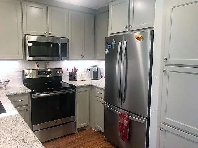 a kitchen with stainless steel appliances granite countertop a refrigerator stove and microwave