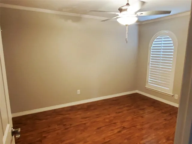 an empty room with a window and a chandelier fan