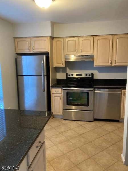 595 Auten Road, Unit 7 Hillsborough, NJ 08844 - Photo 2 of 15 a kitchen with granite countertop a stove and a refrigerator