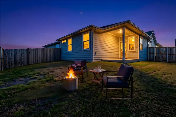 a backyard of a house with yard fire pit and outdoor seating
