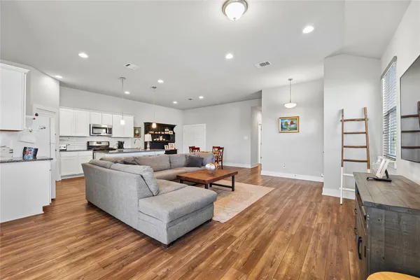a living room with furniture and a wooden floor