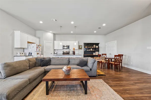 a living room with furniture a dining table and a rug