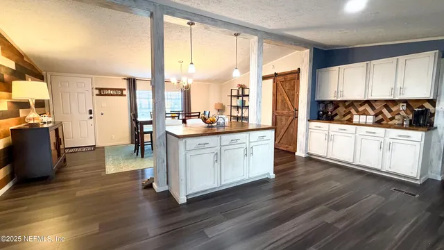 a view of a living room with furniture and a kitchen view