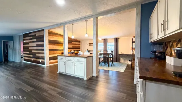 a kitchen with stainless steel appliances granite countertop a refrigerator a stove and a wooden floors