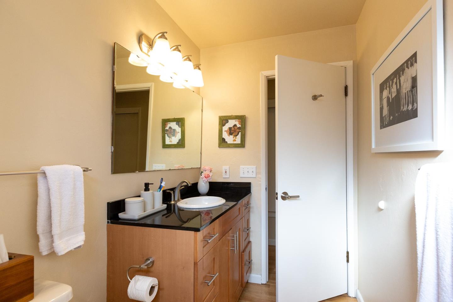 779 Alice Street Monterey, CA 93940 - Photo 19 of 27 a bathroom with a granite countertop sink and a mirror