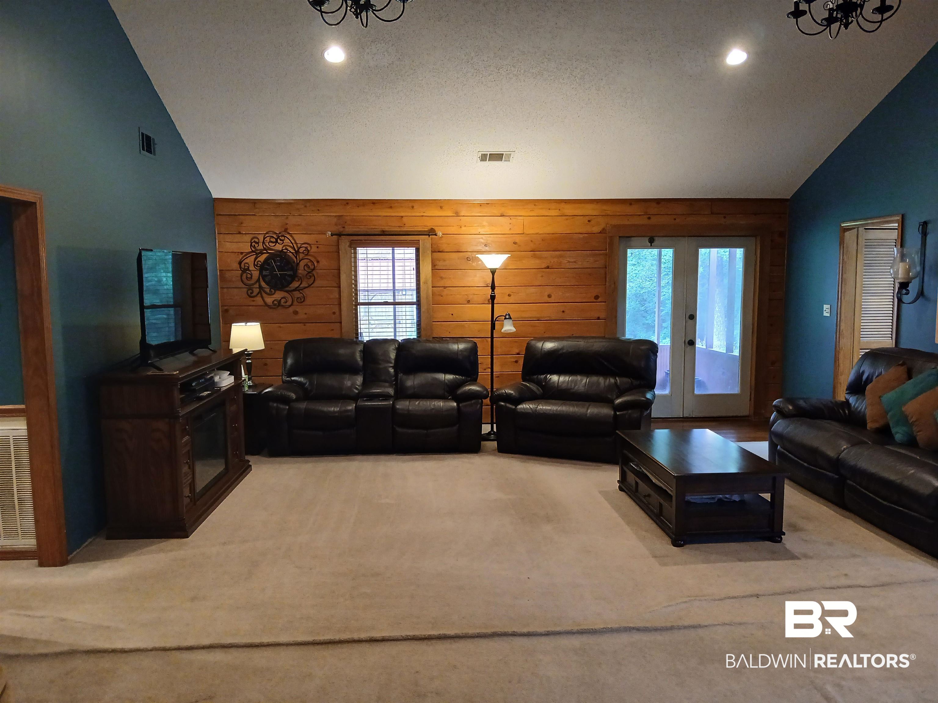 190 Magnolia Court Axis, AL 36505 - Photo 12 of 28 Living room featuring a textured ceiling, carpet floors, french doors, high vaulted ceiling, and wooden walls