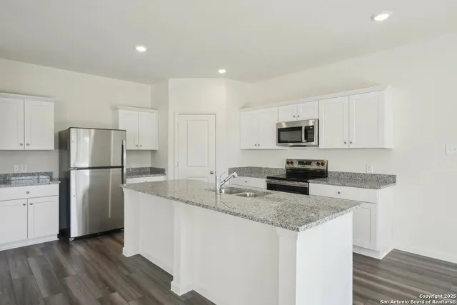 a kitchen with refrigerator stove microwave and sink