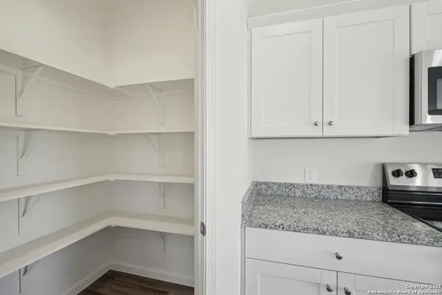 a kitchen with granite countertop white cabinets and a sink