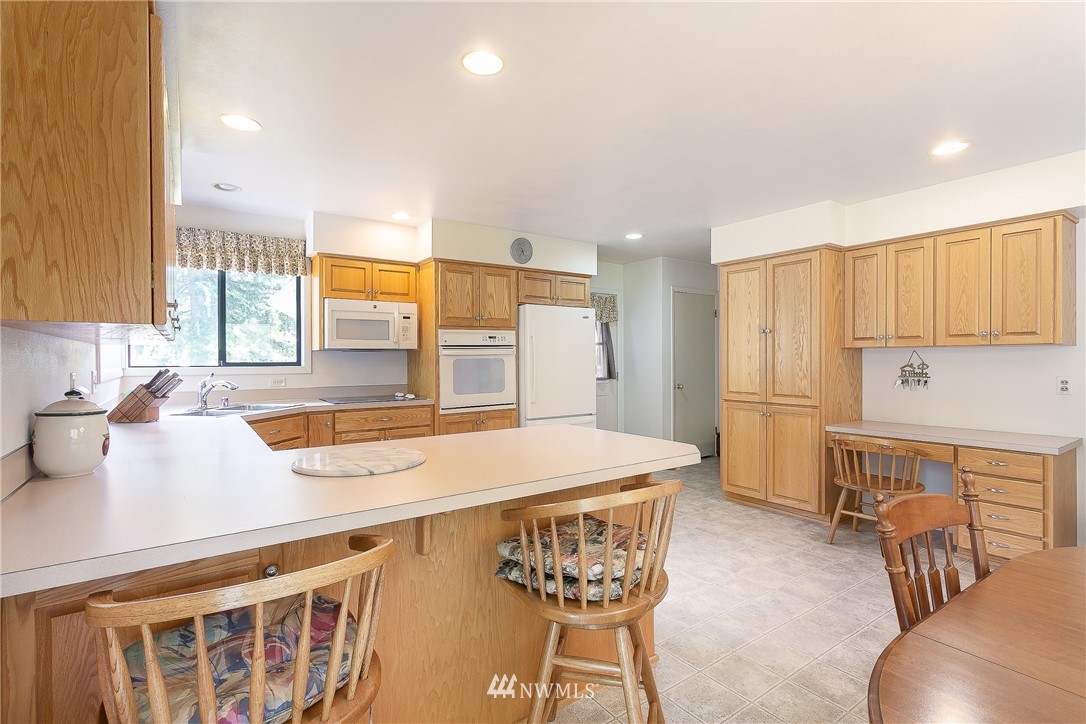 8980 Kendall Road Sumas, WA 98295 - Photo 9 of 39 a kitchen with stainless steel appliances granite countertop a sink a stove a refrigerator cabinets and chairs
