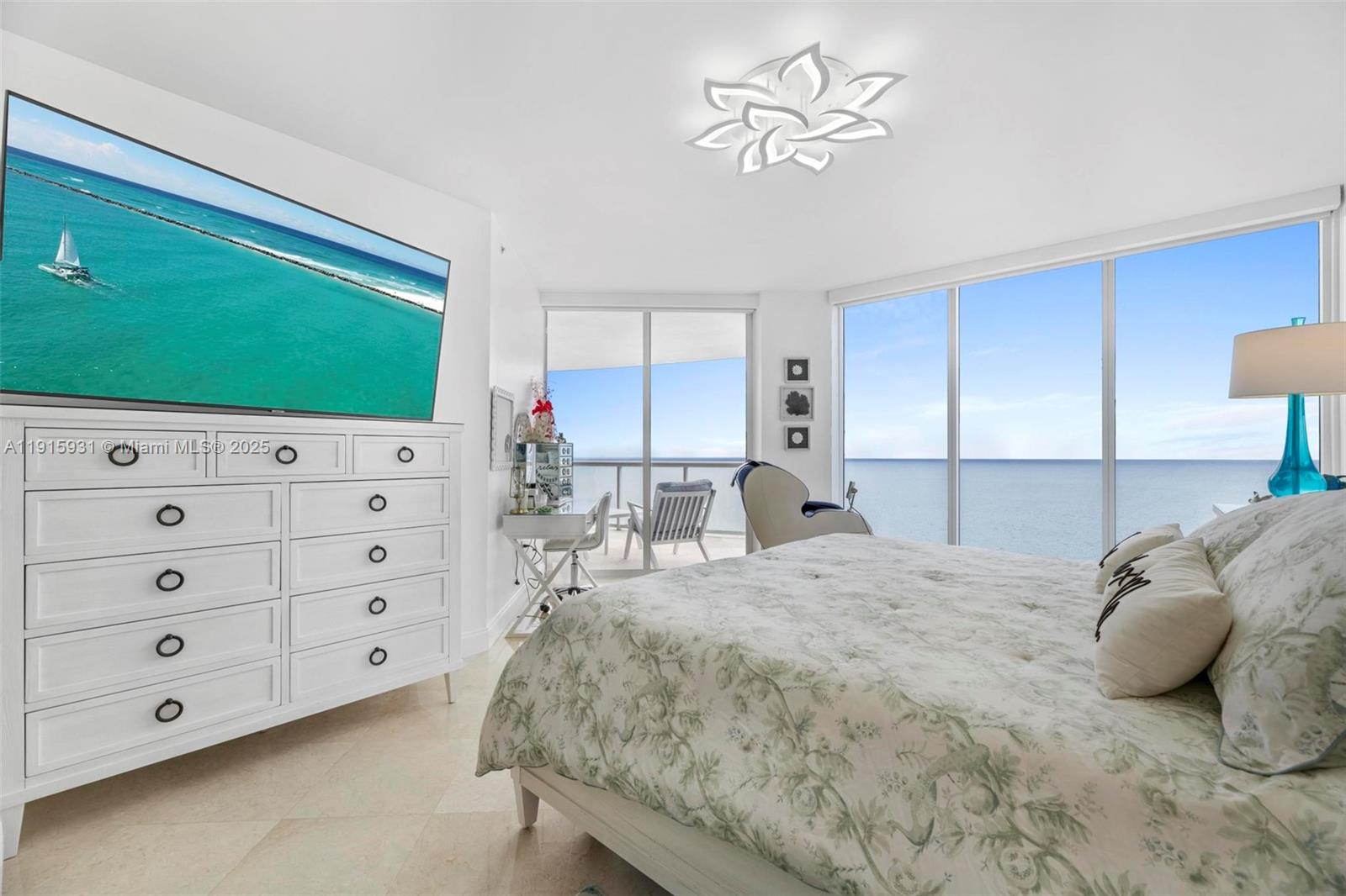 18671 Collins Avenue, Unit 1902 Sunny Isles Beach, FL 33160 - Photo 15 of 53 a bedroom with a bed and a flat tv screen on dresser