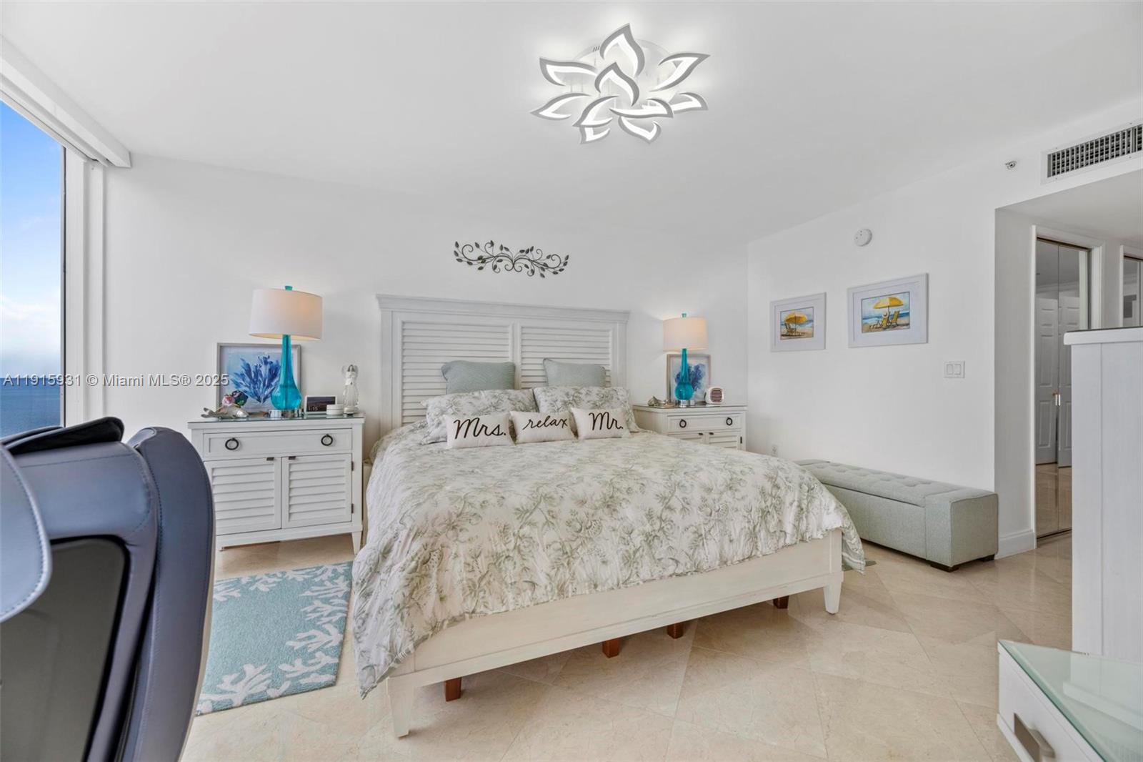 18671 Collins Avenue, Unit 1902 Sunny Isles Beach, FL 33160 - Photo 17 of 53 a bedroom with a large bed and a chandelier