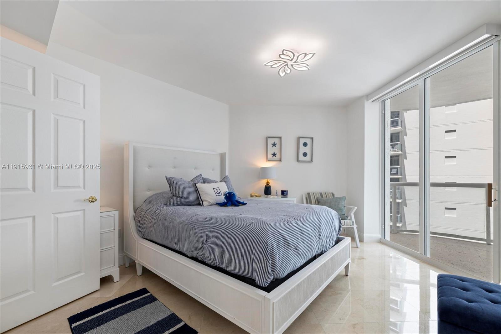 18671 Collins Avenue, Unit 1902 Sunny Isles Beach, FL 33160 - Photo 23 of 53 a bedroom with a bed and a chandelier