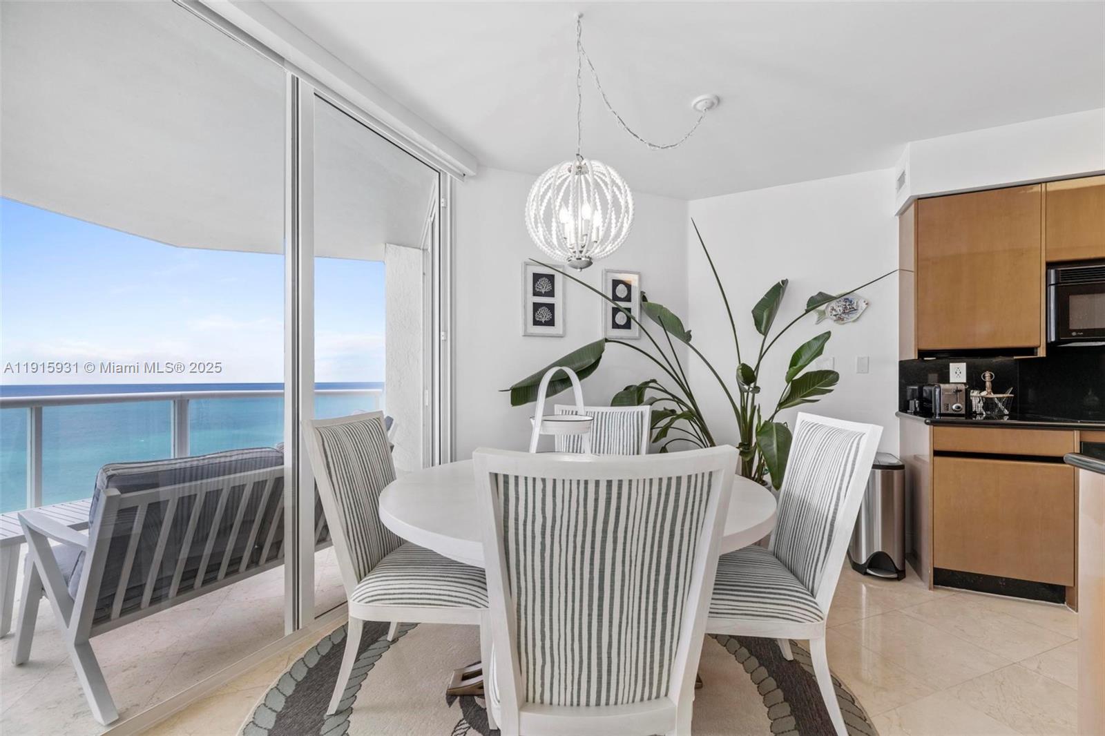 18671 Collins Avenue, Unit 1902 Sunny Isles Beach, FL 33160 - Photo 8 of 53 a view of a dining room with furniture and chandelier