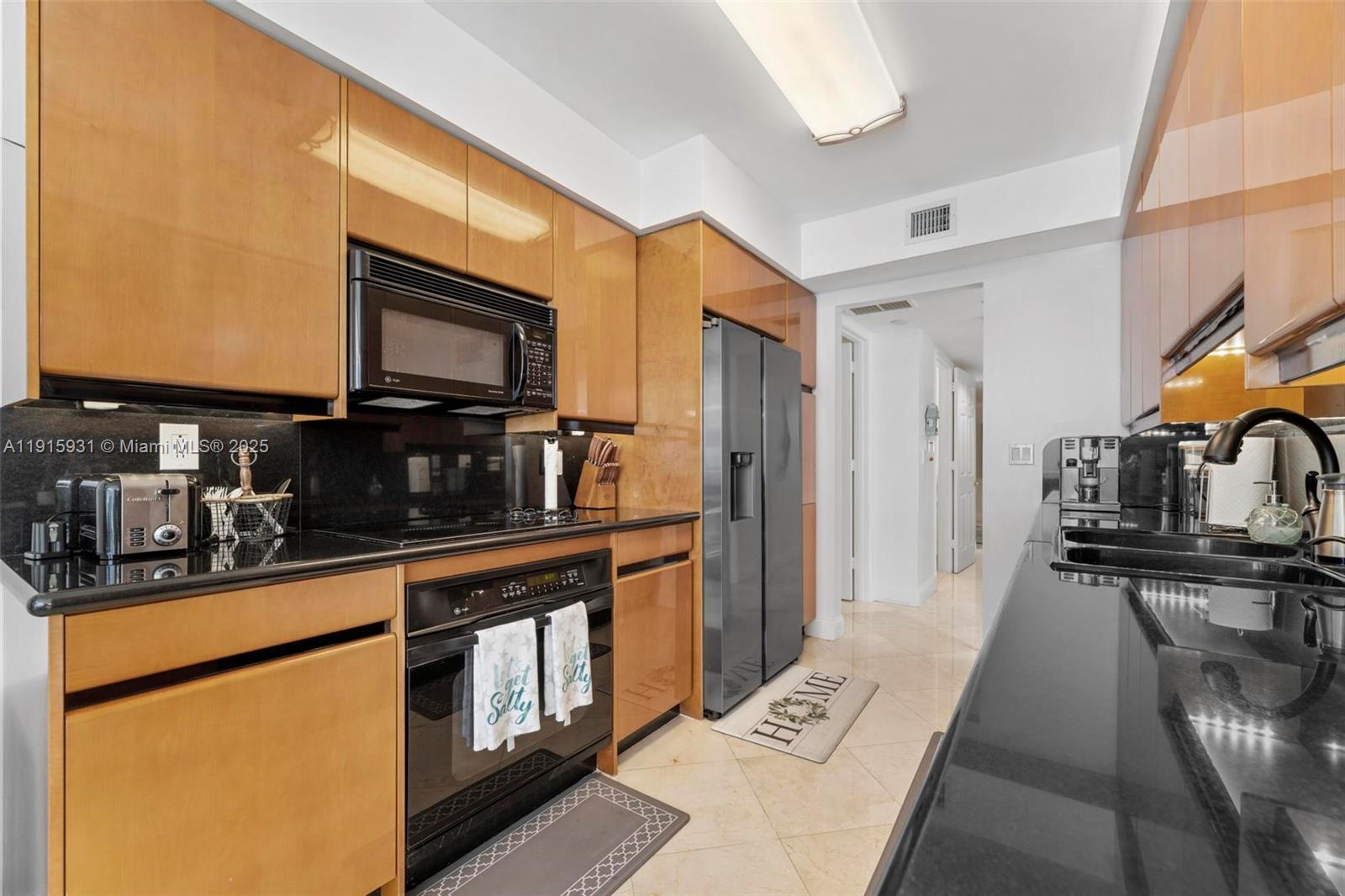 18671 Collins Avenue, Unit 1902 Sunny Isles Beach, FL 33160 - Photo 10 of 53 a kitchen with stainless steel appliances a sink a stove top oven a chimney and a refrigerator