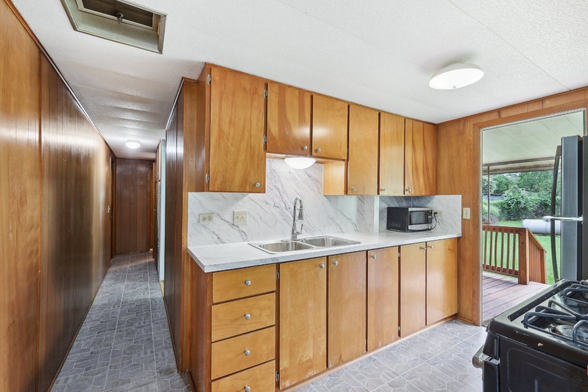 201 Bronco Drive Burnet, TX 78611 - Photo 12 of 30 a kitchen with stainless steel appliances granite countertop a sink stove and cabinets