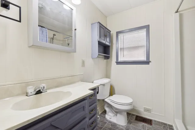 a bathroom with a toilet a sink and mirror