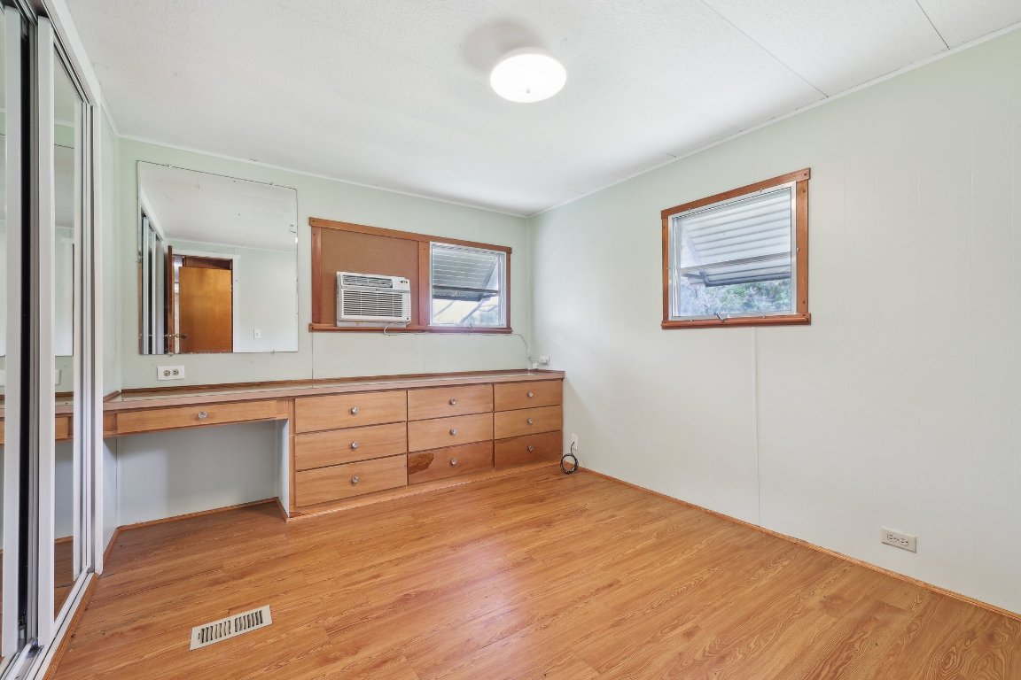 201 Bronco Drive Burnet, TX 78611 - Photo 19 of 30 a room with a bed and a chandelier