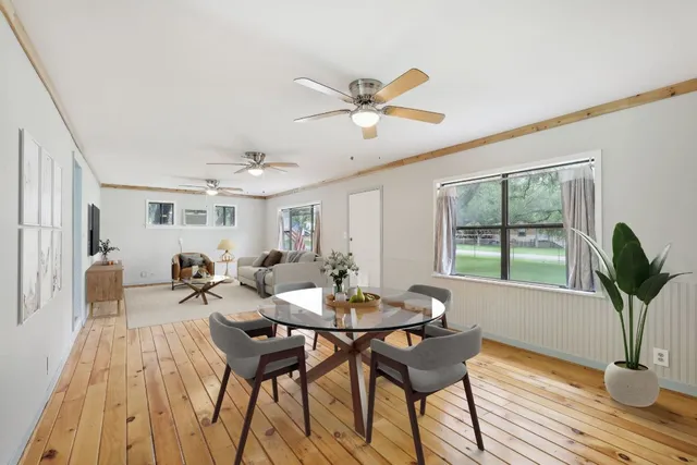 a view of a livingroom and dining room with furniture window and wooden floor