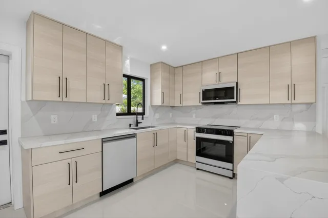 a kitchen with white cabinets stainless steel appliances and sink