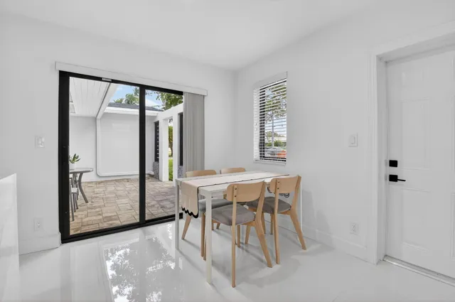 a bedroom with a bed a painting and a window