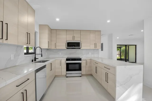 a kitchen with granite countertop white cabinets and stainless steel appliances