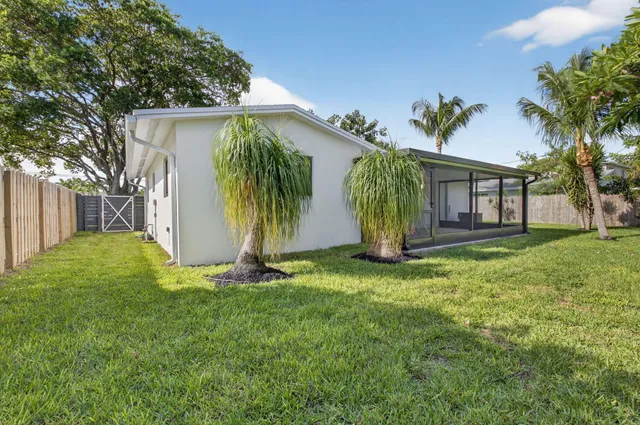front view of house with a yard and potted plants