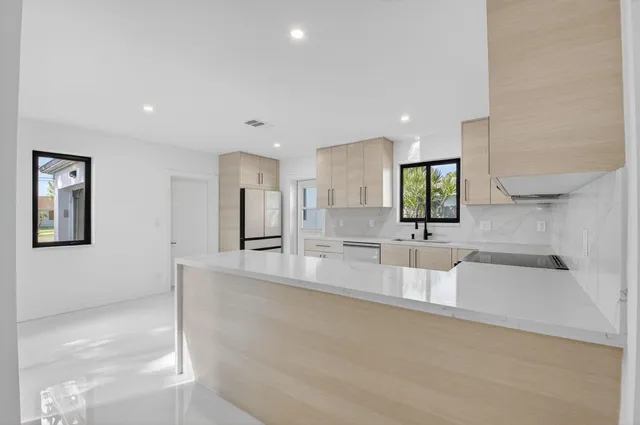 a large white kitchen with a large window