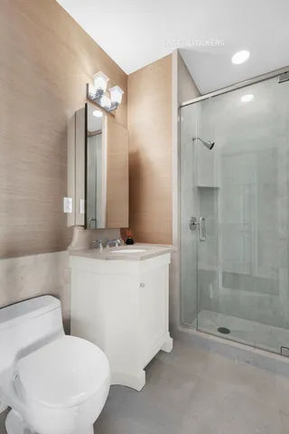 a bedroom with a bed a mirror on dresser and a chandelier