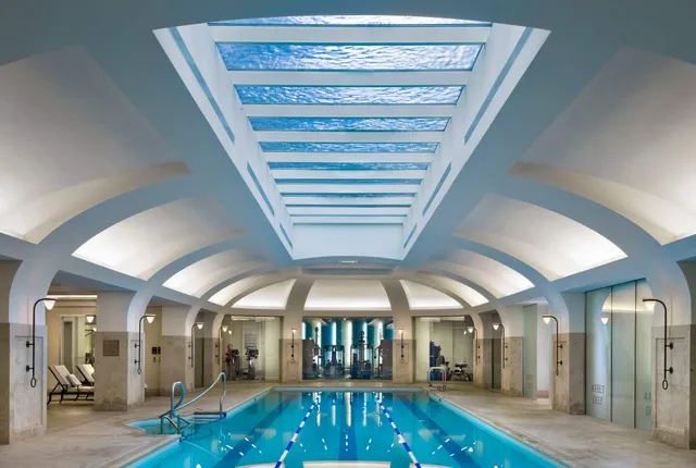 a view of staircase with lots of frames on wall and a chandelier