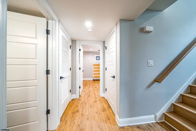 a view of a hallway with wooden floor and staircase