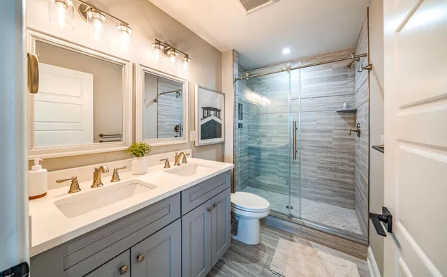 a bathroom with a sink a toilet and shower